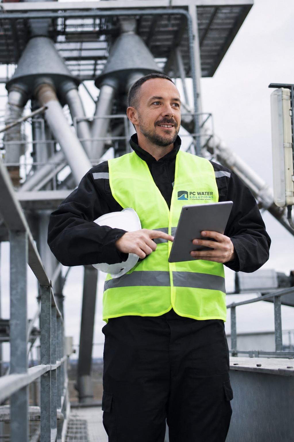 Michael Spiller on site holding a tablet and hard hat